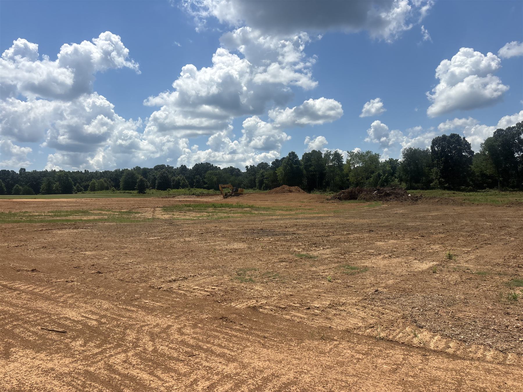 Pond and site excavation in an open field