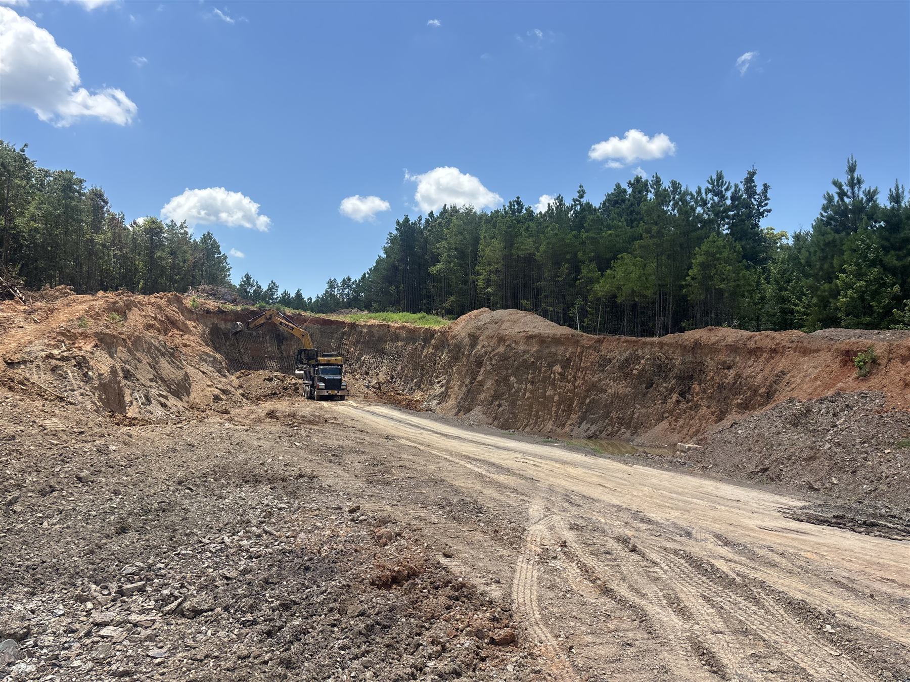 Excavator loading a dump truck in a dirt pit